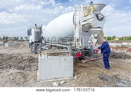 Driver is assembly pouring ram on mixer truck after washing must be prepared for transport in traffic.