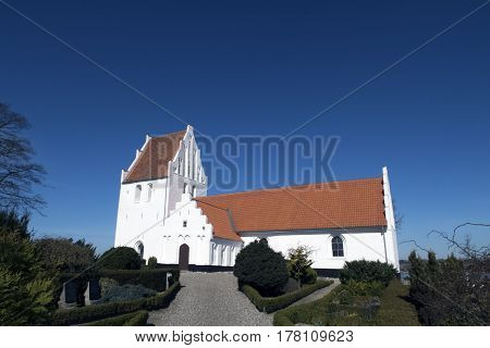 Old traditional Danish white village church in Fons on Funen.