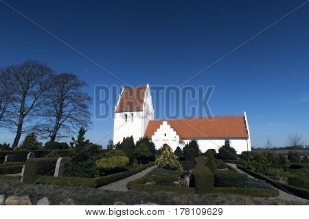 Old traditional Danish white village church in Fons on Funen.