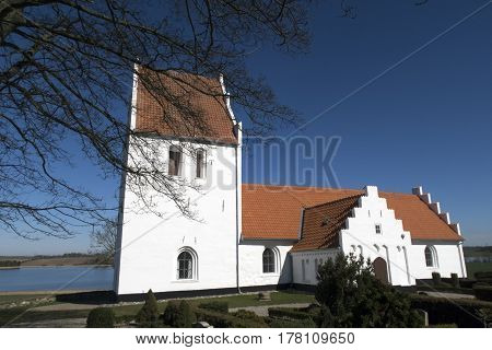 Old traditional Danish white village church in Fons on Funen.