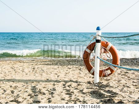 Lifebuoy on a sandy sea beach in Terracina Italy. Safe swimming in the sea and ocean. Background for a marine theme or safety during vacation