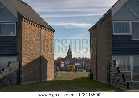 ASSENS DENMARK - MARCH 24 2017: Modern designed Danish terraced summer houses by the sea. Assens church in the background. March 24 2017 Assens Funen Denmark.