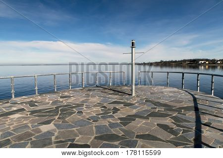 ASSENS DENMARK - MARCH 24 2017: Very small lighthouse at the end of the modern designed walkway on pier a springtime day close to the sea. March 24 2017 Assens Funen Denmark.