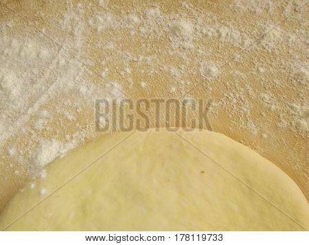 Wooden board with flour and dough. Background. A photo