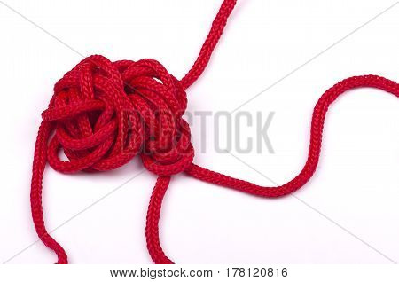 a tangle of matted red rope on a white background closeup