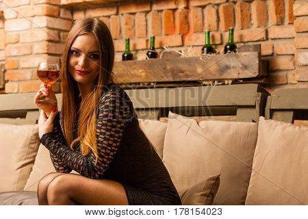 Woman Tasting Wine In Rural Cottage Interior