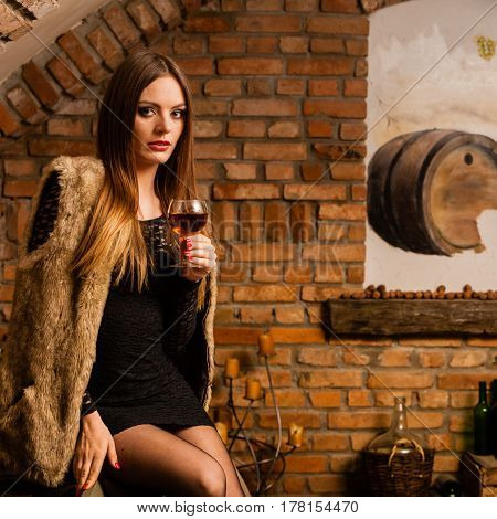 Woman Tasting Wine In Rural Cottage Interior