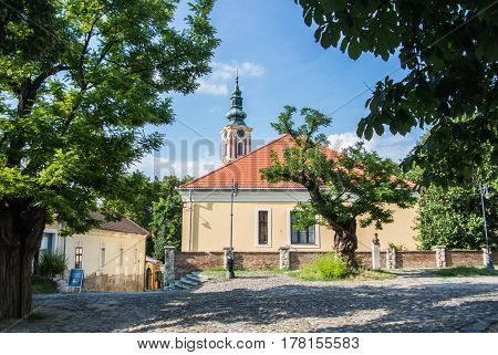 SZENTENDRE HUNGARY - JULY 26 2016: Old house with tile roof and a church in the center of Szentendre little touristic town near Budapest Hungary.