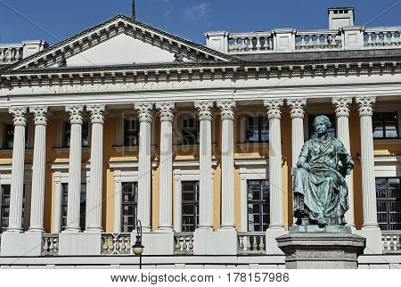 Sculpture of a woman against the background of the front facade of the public library of them. Raczynski in Poznan