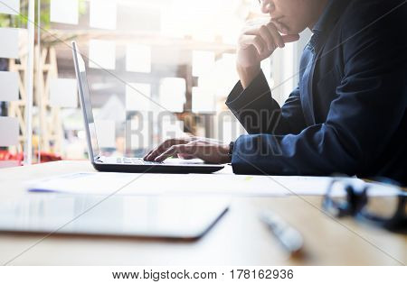 Startup businessman working analysis business information at office with laptop and documents on his desk.