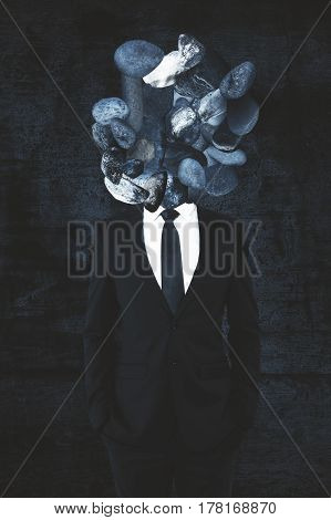 Rock headed businessman on concrete background. Close up.