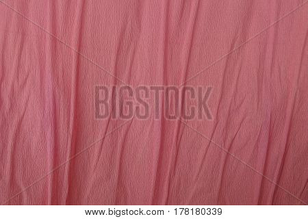 Pink background of a roll of crumpled paper