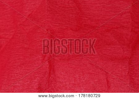 Red bright background of a crumpled piece of paper