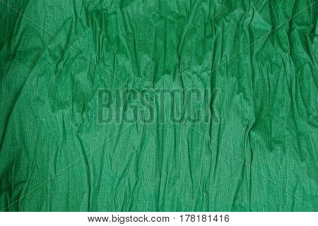 Green background of a roll of crumpled paper