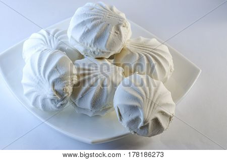 White vanilla marshmallows in a plate on a white background