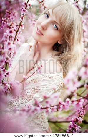 portrait of a beautiful blonde girl in a flowering garden