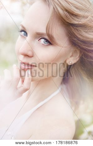 portrait of a beautiful blonde girl in a flowering garden