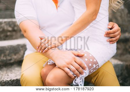 Girlfriend sitting in the lap. A loving couple is sitting on the stairs in Montenegro.
