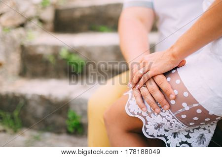 Girlfriend sitting in the lap. A loving couple is sitting on the stairs in Montenegro.