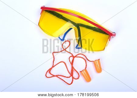 Orange earplug , hard hat, safety glasses, gloves. Earplug to reduce noise on a white background. you can place your text