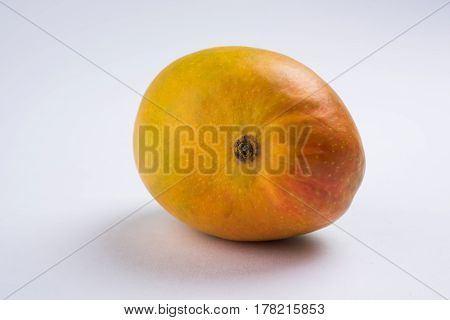 King of fruits; Alphonso yellow Mango fruit duo with stems and green leaf isolated over colourful background, a product of Konkan from Maharashtra - India