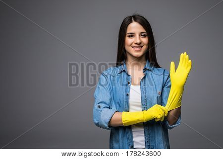 Cleaning lady getting spring cleaning ready putting on rubber gloves. Cleaning woman smiling happy at camera