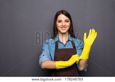 Cheerful Housewife Putting On Gloves Before Cleaning