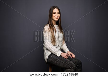 Portrait Of Pretty Young Woman With Long Hair In White Shirt Sitting On Stool Chair