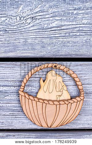 Easter cutwood figurines. Rabbits in a basket. Easter holiday symbols.