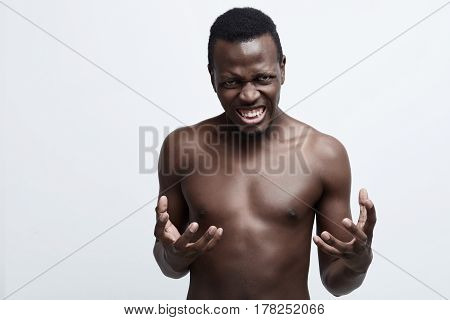 Close up isolated portrait of young annoyed angry African American shirtless man holding hands infurious gesture.Negative human emotions face expressions