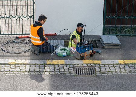 PARIS FRANCE - MAR 24 2017: Team of workers from telecomunication internet provider company working on implementation of fiber optic cables in sewage system - aerial view