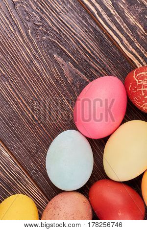 Bright Easter eggs, brown wood. Colorful chicken eggs.