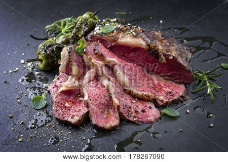 Barbecue aged Wagyu Tagliata di Manzo with Sweet Peppers as close-up on slate 
