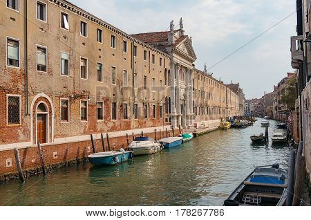 Channel With Boats And Historic Buildings On Embankment. Venice, Italy