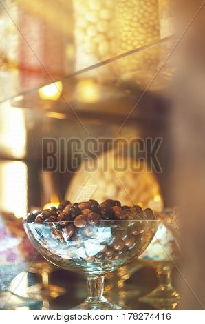 Rich variety of chocolates and candies in display window of italian pastry shop at sunny day at the street of Florence