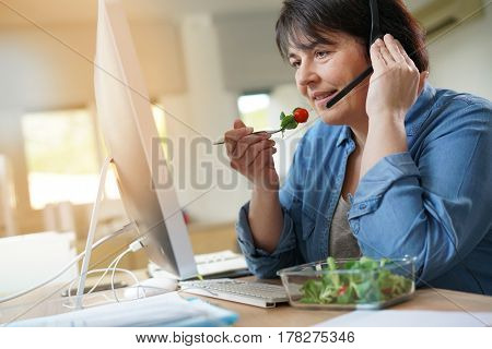 Telemarketing operator having lunch at work