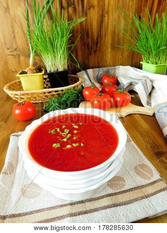 Vegetable soup consisting of beet ,tomatoes and other ingredients in a bowl, The soup is red on the wooden background