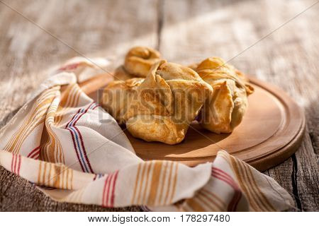 Pies in peasant style on a wooden rustic table. Morning light. Selective focus.