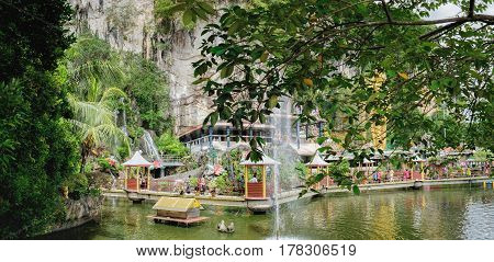 Batu Caves, Malaysia - February 7, 2016: Beautiful pond with gazebo for walking tourists at the entrance to the Batu Caves Malaysia