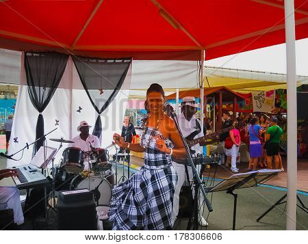 Point-a-Pitre, Guadeloupe - February 09, 2013: Street entertainers with tourists at port in Point-a-Pitre, Guadeloupe on February 09, 2013 in the spirit of the colonial city.