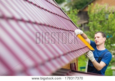 master on repair of roofs makes measurements tool
