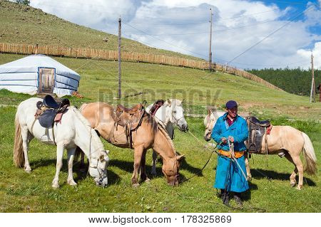 Hanh, Mongolia - July 27, 2016: Mongolian man offers horseback riding