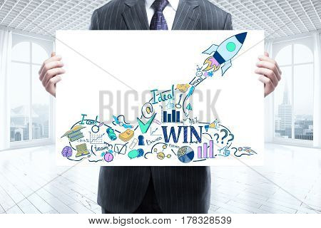 Businessman holding whiteboard with spaceship drawing. Modern interior with city view in the background. Start up concept. 3D Rendering