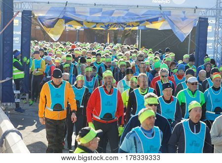 STOCKHOLM SWEDEN - MAR 25 2017: Crowd of runners men and woman in blue vests and yellow bandeau waiting for the start in the Stockholm Tunnel Run Citybanan 2017. March 25 2017 in Stockholm Sweden