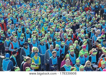 STOCKHOLM SWEDEN - MAR 25 2017: Crowd of runners men and woman in blue vests and yellow bandeau waiting for the start in the Stockholm Tunnel Run Citybanan 2017. March 25 2017 in Stockholm Sweden
