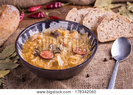Christmas cabbage soup kapustnica with mushrooms bread and spoon on natural background.