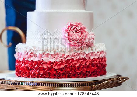 white red pink wedding cake with eatable roses on a side
