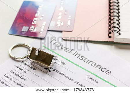 Traveling concept with insurance application form, notebook and credit cards on white table background