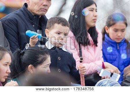 Shymkent, KAZAKHSTAN - 22 March 2017: People Celebrating the Kazakh holiday NARIYZ. Boy with soap bubbles .