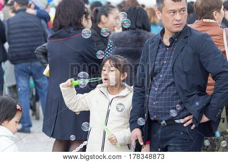 Shymkent, KAZAKHSTAN - 22 March 2017: People Celebrating the Kazakh holiday NARIYZ. Girl with soap bubbles .